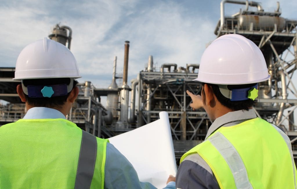 two men pointing at metal structure